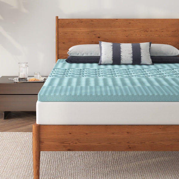 a bed with a blue mattress topper