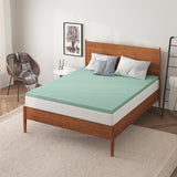 a bed with a green mattress topper